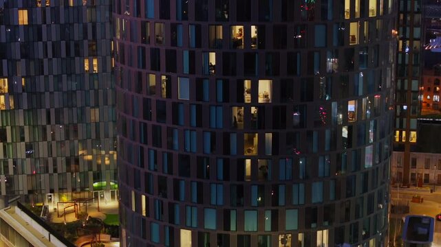City lights and traffic reflections on the glassed facade of a 360 degrees building in Deansgate Manchester 