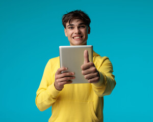young casual man watching movie on pad makes ok sign