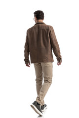 Naklejka premium back view of young man walking and looking to side