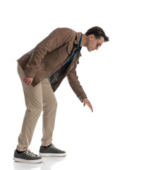 smart casual man waiting in line leaning down to grab