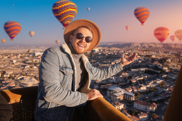 Caucasian young male enjoying hot air balloon ride over avanos, Cappadocia - aerial travel adventure