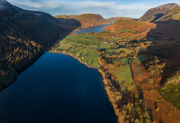 Dramatic aerial drone landscape in Autumn Winter of snowcapped mountains around Buttermere in Lake District at sunrise