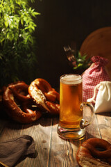 A mug with beer and traditional German bretzels in Bavarian rustic style	