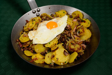 Tiroler Groestl Traditional Tyrolean Fry Up with Potatoes, Meat and Fried Egg Served Country Style in a Steel Pan