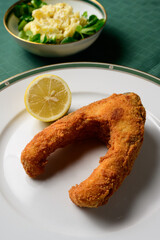 Breaded and Deep Fried Carp Steak with Mayonnaise Potato Salad and a Lemon
