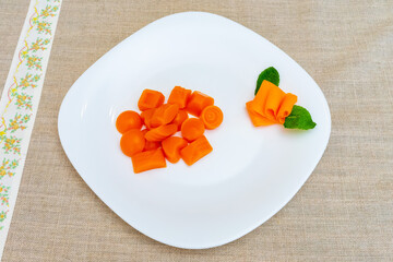 Creative carrot presentation on a white plate with mint garnish