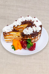 Delicious layered cake with chocolate, fruit, and whipped cream decoration