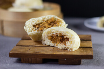 A half eaten pastry sits on a wooden board