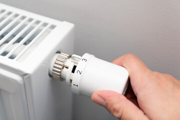 Person is adjusting the temperature on a radiator