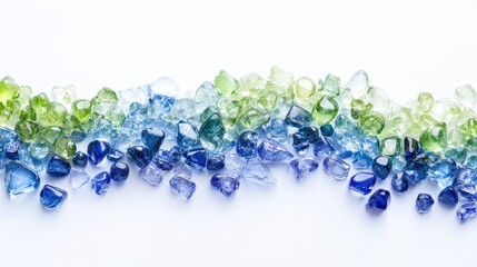 Blue and green gemstones arranged in a wave pattern on a white glossy background.