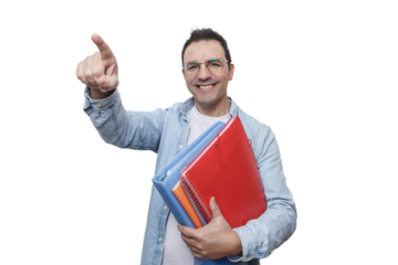 A man smiling and pointing while holding colorful folders in a bright environment.