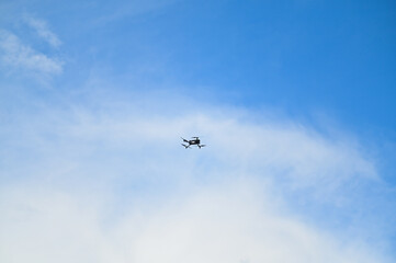 Drone flying High in front of a blue sky