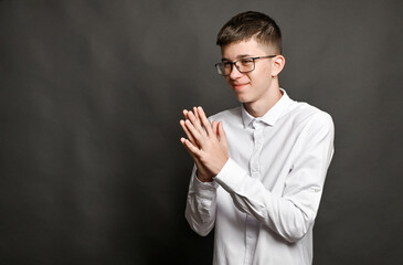 boy with glasses folded his palms in front of him. concept