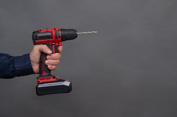 electric screwdriver in the hand of a man.