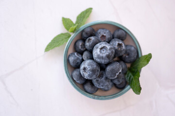 Fresh blueberries and mint leaves resting in a small bowl