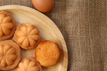 Top view Thai egg cake with or as it is known in Thai, Khanom Khai, on wooden board Made by baking, it is crispy on the outside and soft on the inside. Have copy space