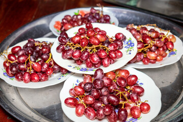The red and purple grapes on a plate are ready to eat Sweet and sour taste for good health, taken in Myanmar.
