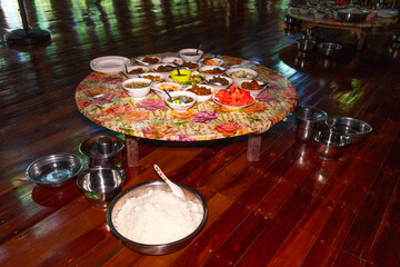 A set of various Burmese curries on the wooden table. Various meat curries, rice, fried fruits, and vegetables.