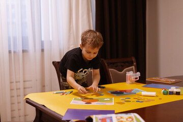 Child paints and makes a collage