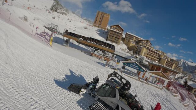 Dynamic aerial drone view of a snow groomer in action, shaping pristine slopes in a snowy landscape. Perfect for winter sports, mountain, and seasonal adventure projects.