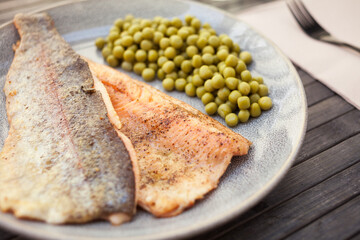 Delicious baked trout fillet with green peas