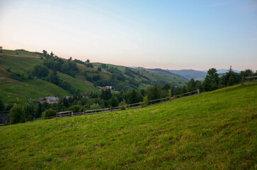 Rolling hills surrounding a quaint village in a peaceful valley