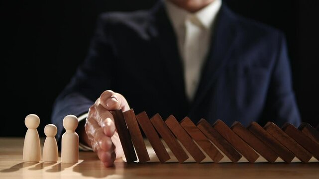 Concept of Risk Assessment, Crisis, Economic, Business Management, Inflation. Hand of businessman stopping, prevent falling block, domino effect to safe family life, property, insurance from crisis.