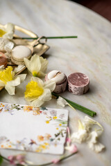 Golden wedding ring in a velvet box with daffodils and a floral card