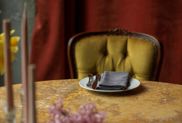 Dinner plate with cutlery and napkin on vintage table close up