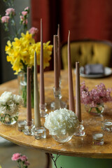 Candles and flowers on a round wooden table for a romantic meeting