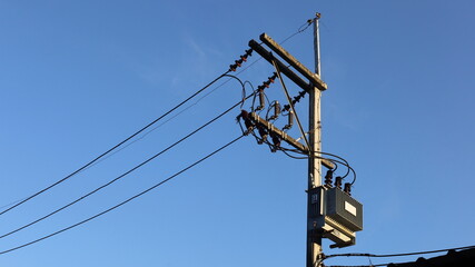 Power transformer on pole. Three-phase transformer with wires on pole with fuse unit and low...