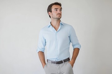 Portrait of a Handsome Young Man Wearing a Light Blue Dress Shirt and Casual Khaki Pants Against a White Background Studio Shot   