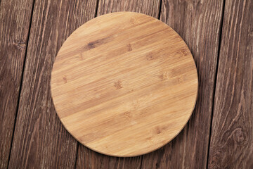 Top view of wooden round tray on wooden table, food background, template for designer