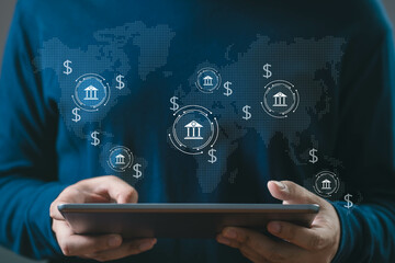 A person holding a tablet with global banking icons and currency symbols, representing digital banking and financial technology trends.