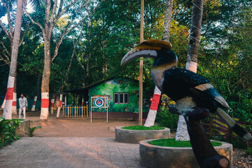 A vibrant outdoor recreational area surrounded by lush greenery, featuring a carved hornbill bird sculpture and a colorful archery target. © DiversePixels