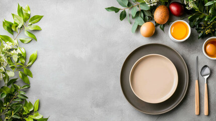 Easter brunch table set with pastel plates, eggs, and greenery on gray background