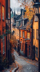 Fototapeta premium Charming cobblestone street in autumn, lined with colorful historic buildings.