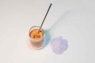 refreshing glass of Thai iced milk tea, served in a clear glass cup. The rich, vibrant orange color of the tea contrasts beautifully with the creamy milk at the bottom. A perfect blend