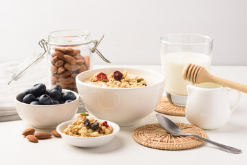 Oatmeal bowl with blueberries, granola, almonds and milk. Healthy breakfast concept.
