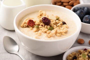 Oatmeal bowl with blueberries, granola, almonds and milk. Healthy breakfast concept.