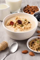 Oatmeal bowl with blueberries, granola, almonds and milk. Healthy breakfast concept.