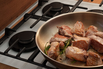 A large steel pan in which meat is fried with rosemary for the kitchen. Close. Recipe. Homemade food.