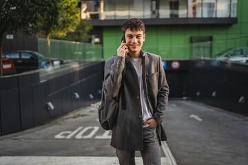 happy adult young man and talk on mobile phone on the street