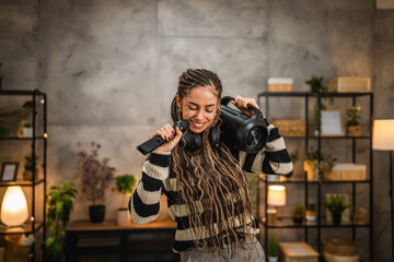 happy young woman dance and listen music on loudspeaker and sing