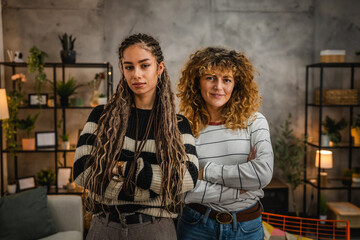 portrait or two curly hair female friends have fun at home