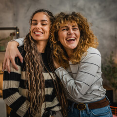 portrait or two curly hair female friends have fun at home