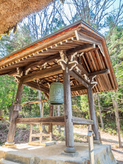 Ancient bell tower in Japanese style at outdoor public park near woods in Japan