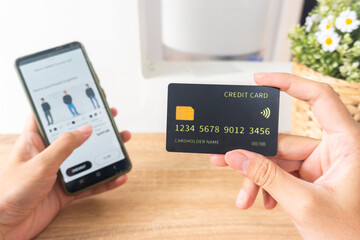 Pov first person holding black mockup credit card for online shop on smartphone at home