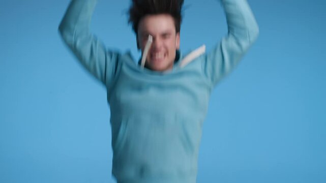 surprised casual man looking down on telephone then jumping in the air to celebrate a big win