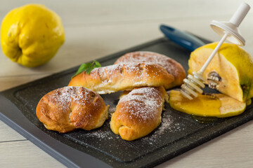 Pastries. Sweet buns with quince and honey filling, on a wooden table